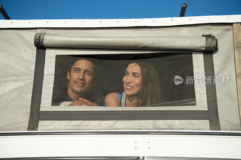 夏日里，一对年轻漂亮的夫妇坐在露营车里