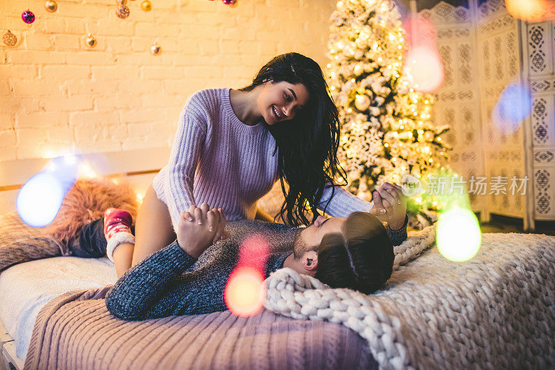 激情浪漫的情侣在新年前花时间在家里美丽的圣诞树附近