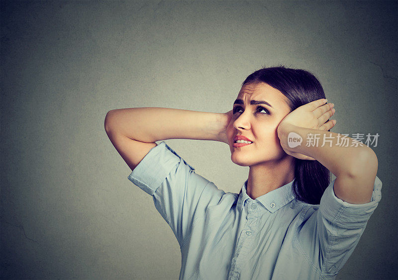 压抑沮丧的女人用手捂住耳朵。