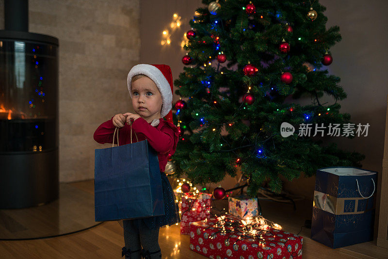 一个小女孩拿着圣诞礼物。