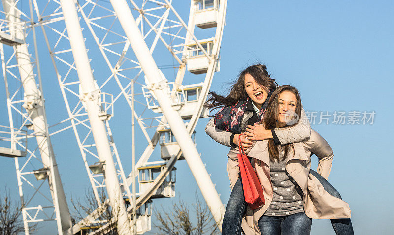 年轻女性最好的朋友享受时间一起在摩天轮-自由和幸福的概念与两个漂亮的女朋友在月球公园玩-自然下午色调滤镜