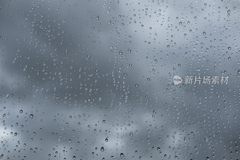 透过雨点覆盖的窗户观看阴沉的天空。