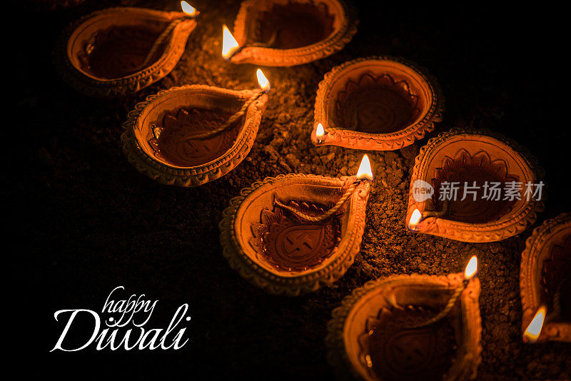 快乐的排灯节贺卡设计使用美丽的粘土diya灯在排灯节之夜庆祝。印度灯节称为排灯节，一个光的节日