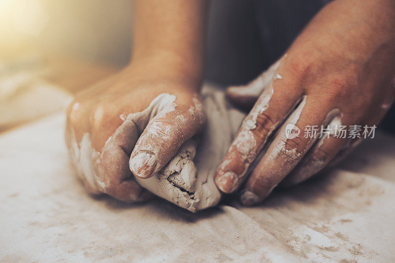女陶工用陶土工作，工匠的手靠近