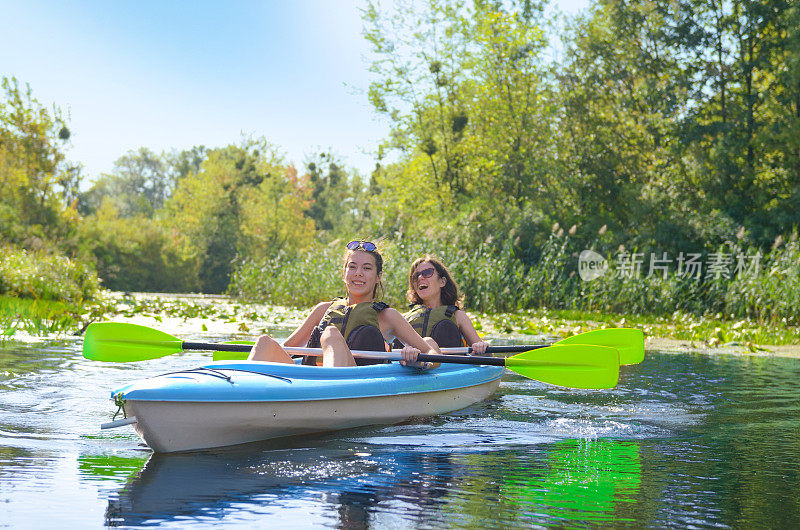 家庭皮划艇，母子皮划艇河上独木舟之旅，活跃的秋季周末和假期，运动和健身的概念
