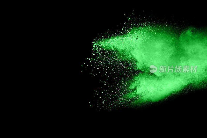 摘要绿色粉末在黑色背景上爆炸。抽象的绿色尘埃飞溅在黑色背景上。冷冻运动的绿色粉末飞溅。