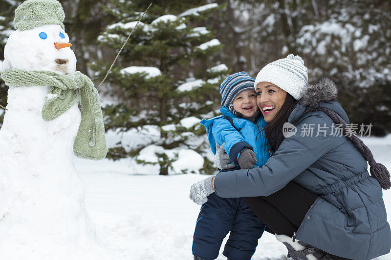 爸爸和妈妈带着他们的孩子，在雪里玩。