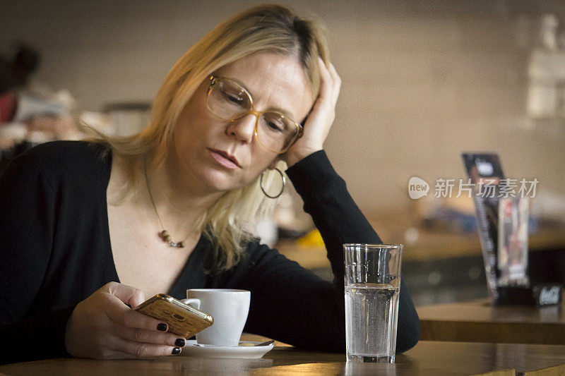 一个女人正在餐厅里喝咖啡，看留言