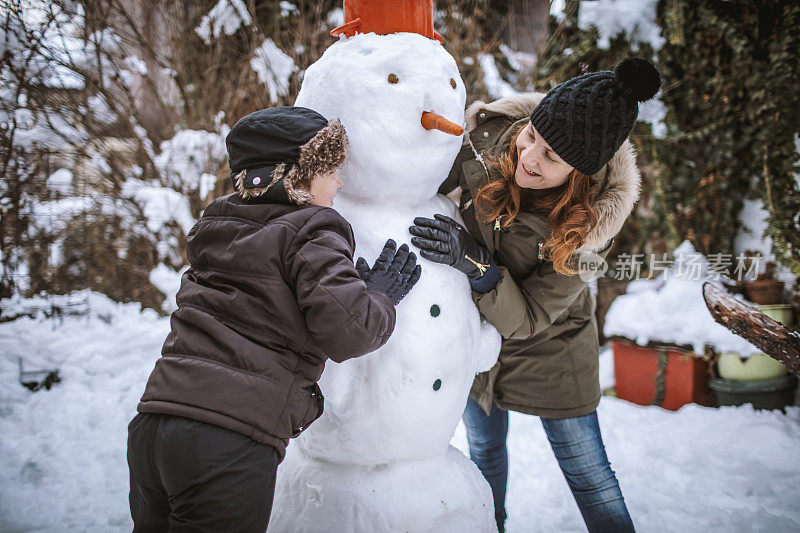 妈妈和儿子在堆雪人