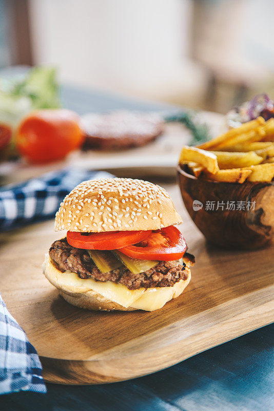 经典的牛肉汉堡配上炸薯条，以生料为背景