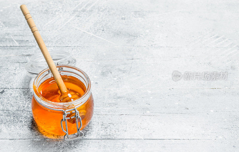天然蜂蜜在罐子与木勺。