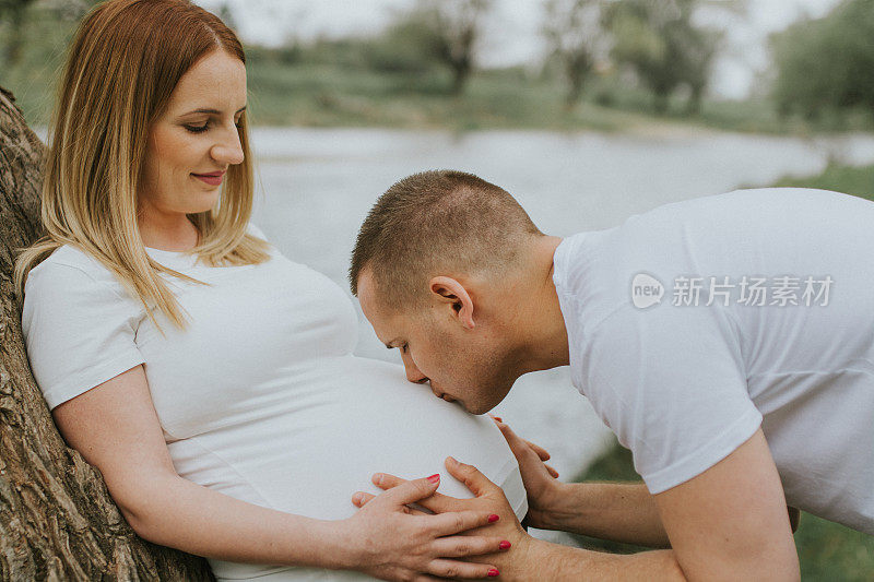 我在亲吻我的妻子和她肚子里的新生儿