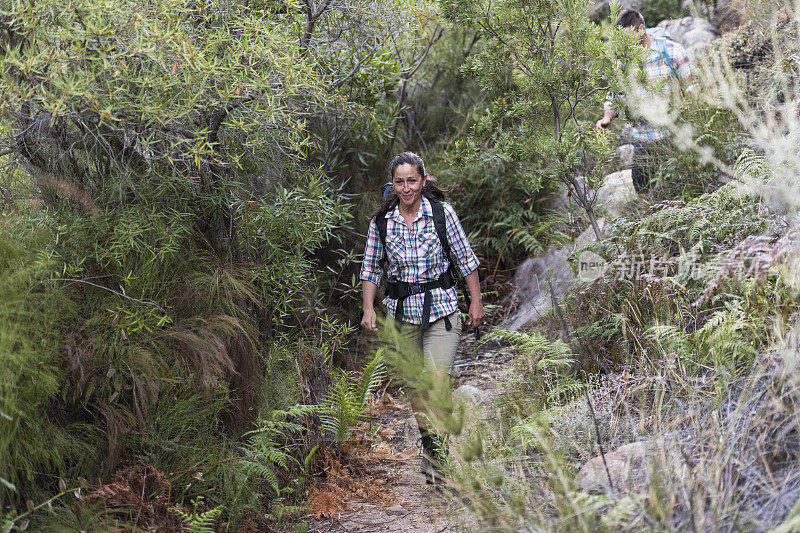 女性徒步旅行者在山间小径上行走