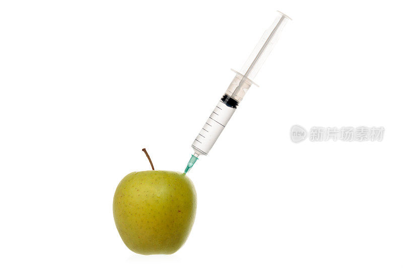 用注射器将无色液体注入一个孤立的白色苹果中。
