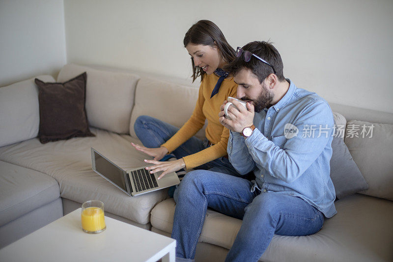 年轻夫妇在客厅里用一台电脑