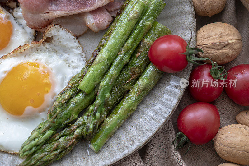 自制健康早餐:煎蛋、培根、蔬菜和坚果