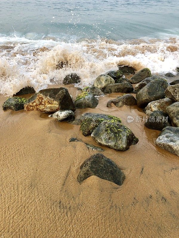 印度南部喀拉拉邦Kollam海滩，海岸岩石与汹涌的海浪，海藻覆盖的巨石