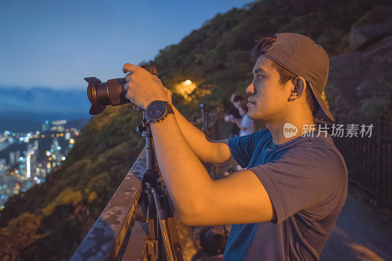 年轻的亚洲游客冒险拍摄香港的城市天际线在香港的famaus旅游胜地维多利亚峰