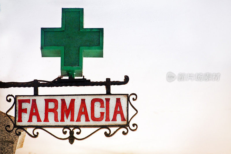 西班牙语药房标志，铸铁框架，绿色十字标志。