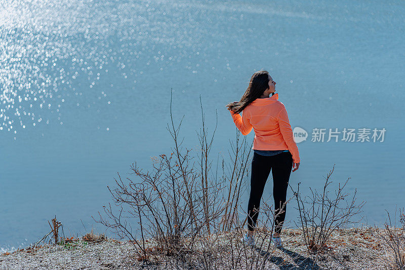 一个年轻女子望着远处的湖