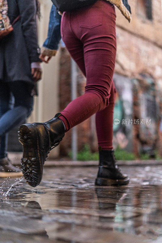 两个女性朋友在雨天撑着雨伞在户外散步