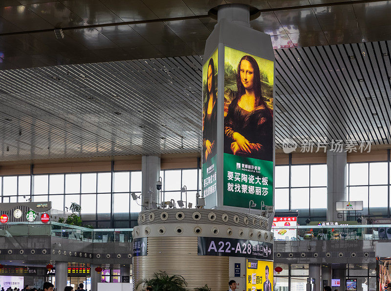 在南宁南火车站巨大的出发大厅里，一块用蒙娜丽莎画的广告牌为一个中国瓷砖品牌做广告