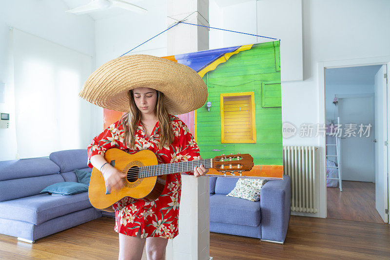 年轻的女孩假装在假期在墨西哥多彩的村庄弹吉他在假的背景
