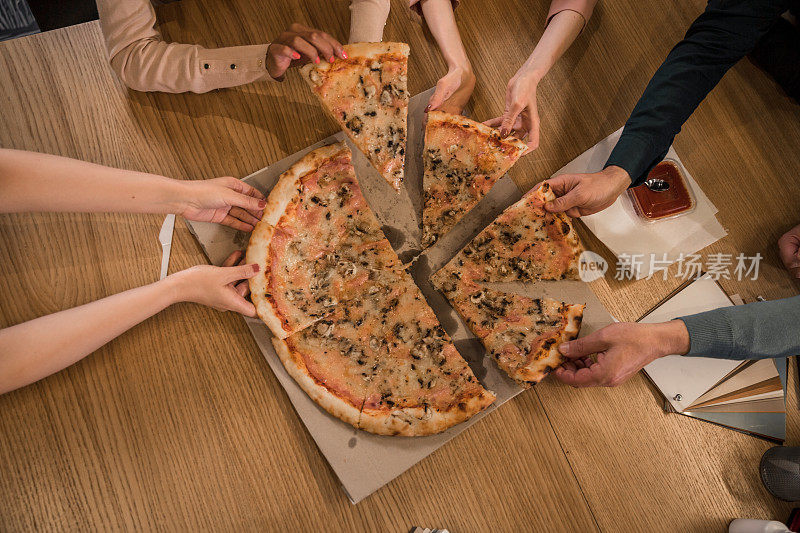 一群不认识的人一起分享披萨