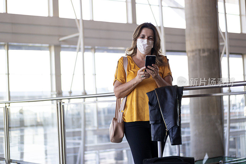 一个女人在机场拿着手机。