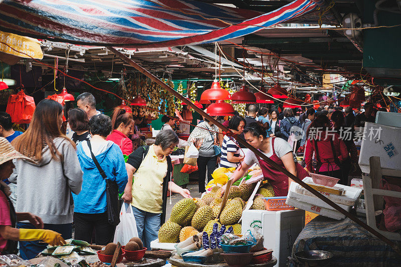 人们在香港的街头食品市场上购买蔬菜和水果
