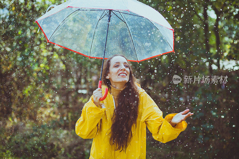 快乐的女人在雨中行走