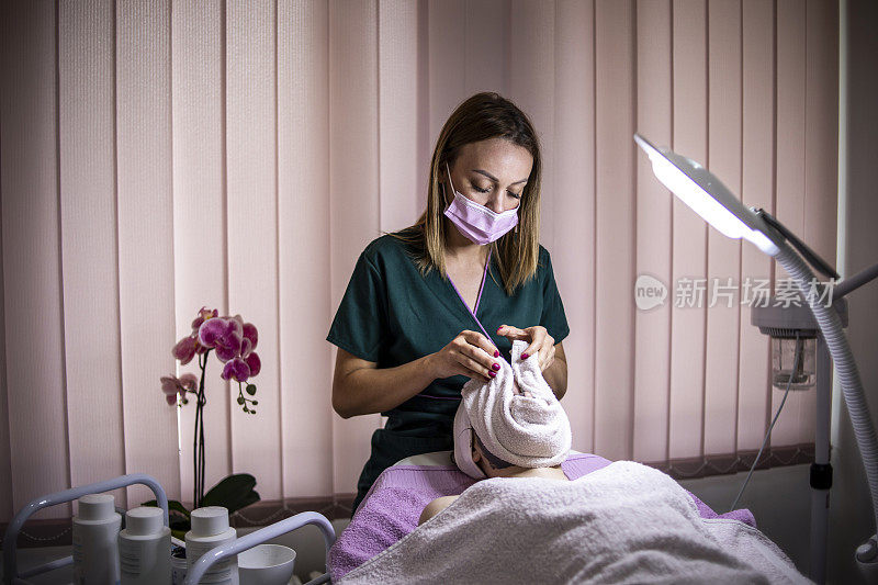 美丽的女人在水疗沙龙的面部按摩-抗衰老疗法-年轻化和面部清洁