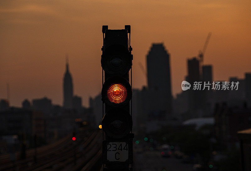 夕阳西下的纽约皇后区地铁列车，以帝国大厦为背景