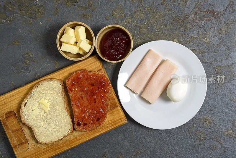 黑麦面包片，黄油，草莓酱，鸡蛋和火鸡火腿