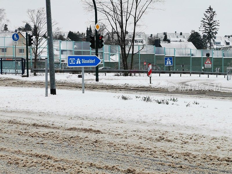 高速公路标志杜塞尔多夫A52在一个红绿灯被雪包围