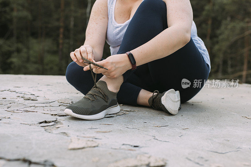 匿名加码女人系鞋带的运动鞋，一个近距离