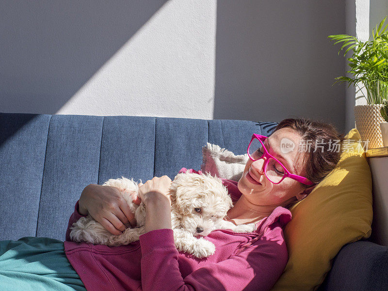 一个女人在家里抱着她可爱的狗狗