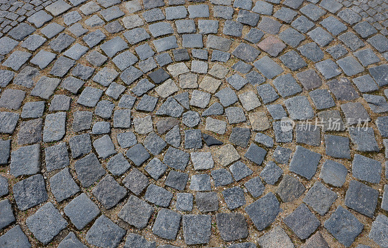 广场上有一个大的深灰色的圆圈里面有一个小圆的鹅卵石立方体。石头是花岗岩和玄武岩。在历史悠久的市中心，马车或豪华轿车转弯的地方