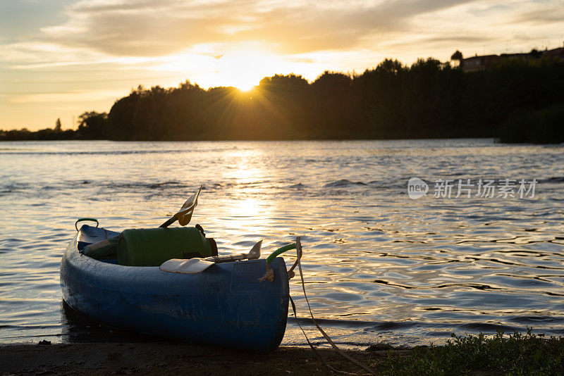 黄昏时分，一只独木舟停泊在河岸边