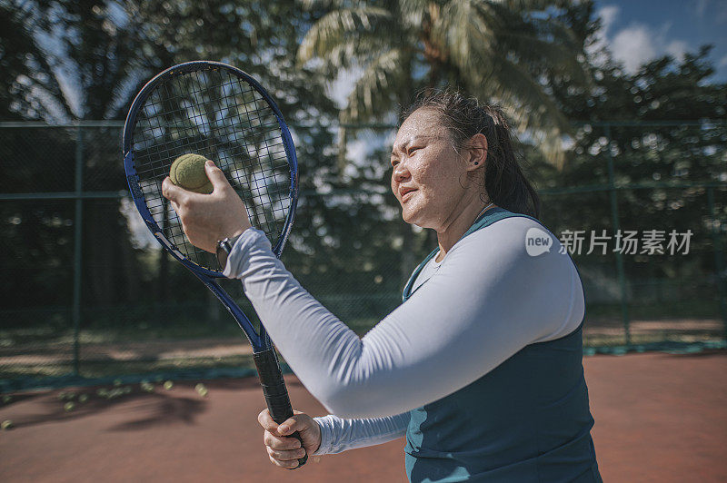 亚洲中国妇女练习服务在网球场周末上午