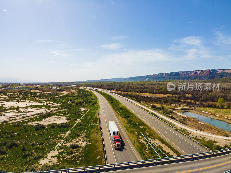 在美国西部70号州际公路和立交桥上驾驶的车辆和半卡车的无人机视图的红色半卡车向西行驶的科罗拉多州Fruita照片系列