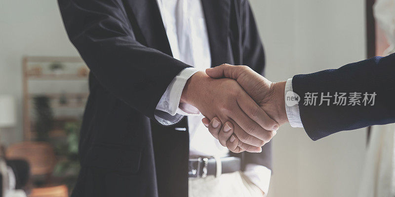 两个自信的商人在办公室开会时握手，成功、交易、问候和伙伴概念。
