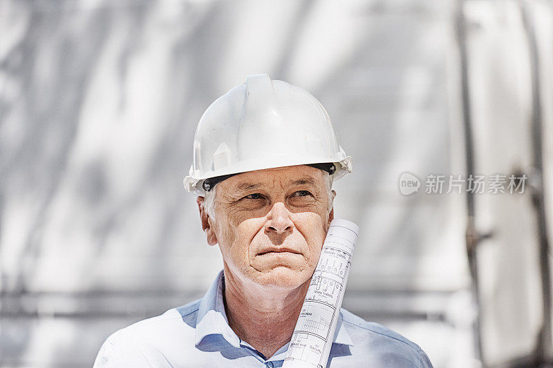 戴着安全帽手持建筑图则的土木工程师、建筑工人、建筑师或经理
