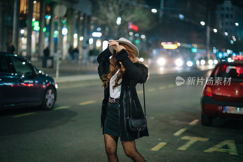 一名女子站在城市的路上叫出租车