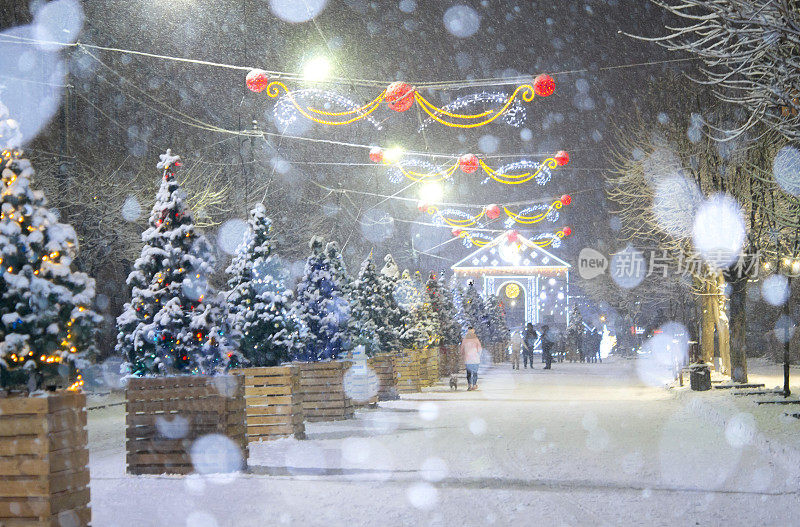 冬夜降雪时的城市街道。漂亮的照明装饰