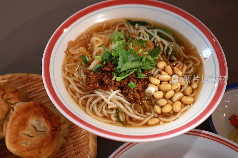 特写一碗重庆传统汤面，上面有猪肉末、豆子和葱花。