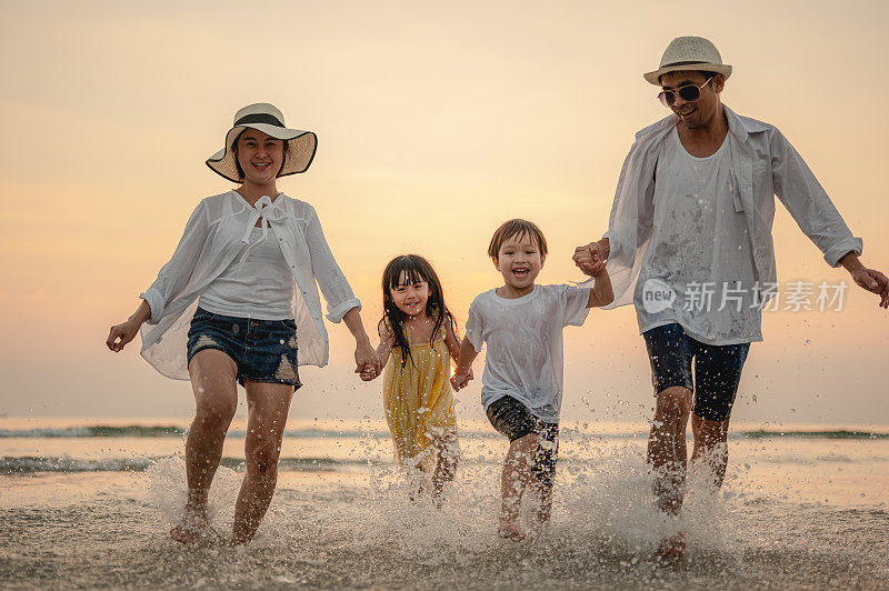 快乐的亚洲家庭在日落的海滩上玩海。享受野餐的家人。家庭，旅行，海滩，放松，生活方式，度假概念。
