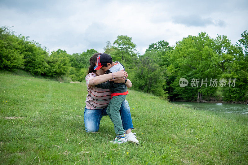 阿姨和侄子一起在公园的操场上玩耍。