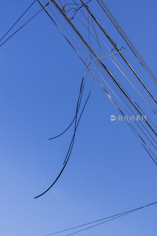 一堆堆的互联网电缆、电话线和电线映衬着蔚蓝的天空。