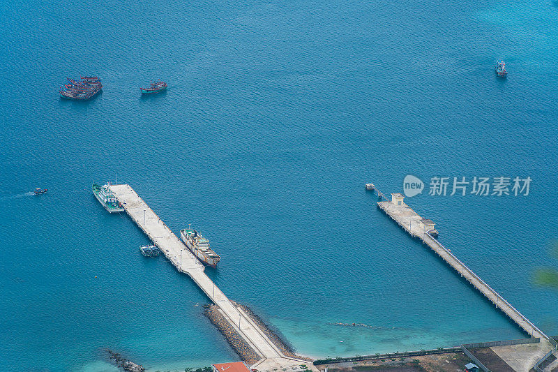 越南孔岛本丹港，湛蓝的大海，蓝天山和五颜六色的船只。